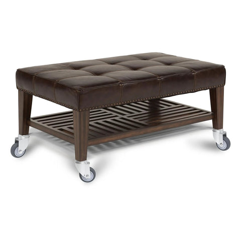 Brown tufted leather ottoman with wooden frame and four caster wheels; lower slatted shelf.
