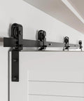 Close-up of 52 Inch Bi Folding Sliding Barn Door Hardware Track Kit For Small Spaces With Smooth And Quiet Operation Side Mounted Black Rollers Easy Install Door Not Included Fits Four 12 Inch Bifold Doors installed on wall.