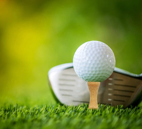 Golf ball on Step Down Golf Tees 2 1/8 Inch, 2 3/4 Inch, and 3 1/4 Inch, 100 Pack Wooden Bamboo Castle Tees Natural Finish in grass