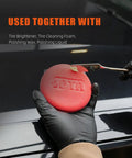Close-up of 10 Pack Foam Wax Applicator Pads For Car Detailing, 4 Inch Red Hand Wax Pads being used on a car hood.