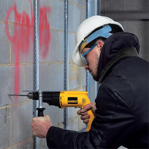 Worker using a Power Through Concrete And Wood With A 1/2 Inch Hammer Drill, 7.8 Amp Heavy Duty on concrete wall