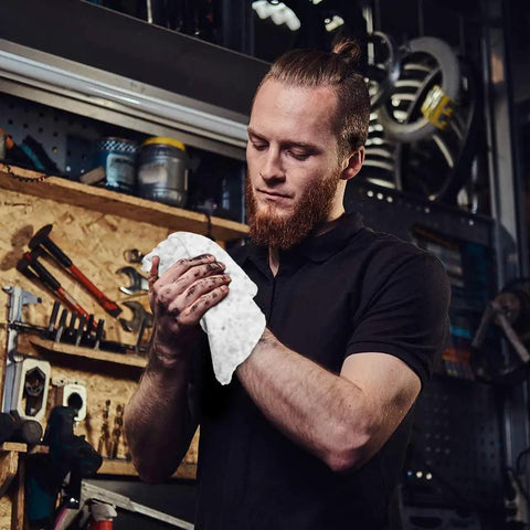 Person using Pro Grade Auto Shop Towels 100 Pack Lint Free 14x14 Bulk Rags Made From 100 Percent Cotton in workshop