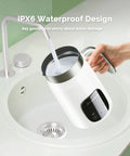 Barista Vibe DualFro 400 Milk Frother being rinsed under a faucet, demonstrating its IPX6 waterproof design.