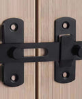 Black sliding barn door lock for privacy in stainless steel, installed on wooden door, secure privacy latch for barn doors, pet doors