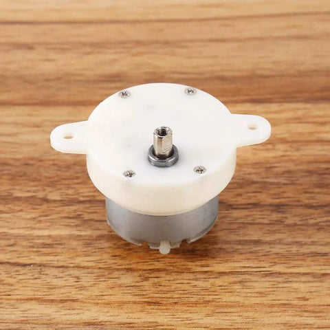 12V Tiny Gearbox DC Motor With 3 RPM Slow Speed High Torque 4mm Shaft Reversible Low Noise on wooden surface