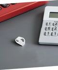 Single plastic flow control clip for tubes on desk near calculator, part of 20 Adjustable Flow Control Clips For Tubes Plastic Hose Clamps For Precise Liquid Regulation In Labs Aquariums Home Brewing Garden Irrigation And DIY Tubing Projects.