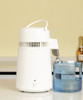Built Tough Water Distiller Machine Packs 750 Watt Heating Coil next to a blue four-liter water catch bucket.