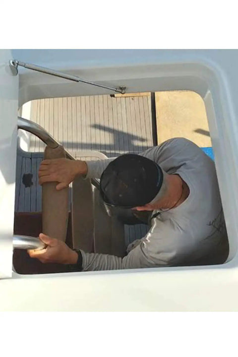 Man using a marine gas spring strut for heavy shop jobs; focus on grip and support, 34 inch and rustproof marine steel.