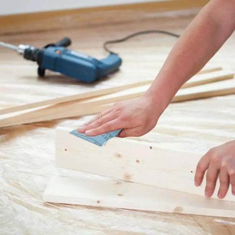 Auto Body Sanding Kit With 28 Pcs Wet Dry Sandpaper Pack used on wooden board, power drill in background