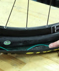 Close-up of bike tire with inserted protector for Bike Tire Liners And Protectors Lightweight Puncture Proof Set For 12 to 26 Inch Tires Fits One And A Half to Two And An Eighth Inches Width Keeps Nails And Debris Out Between Tube And Tire For Two Tires Easy Install.