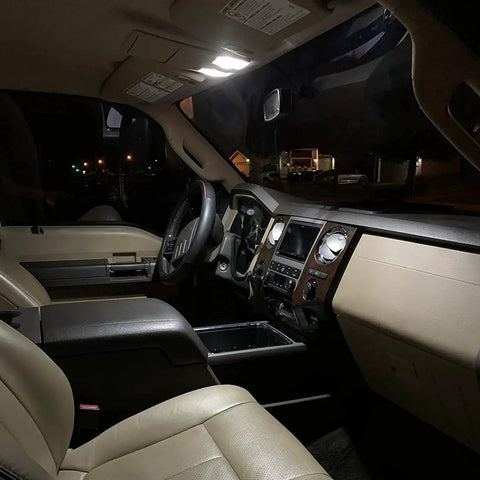 32 Piece LED Car Interior Light Kit With T10 Wedge And Festoon Bulbs For Dome Map Door Trunk Courtesy Lights Bright White Replacement Kit Includes 29mm 31mm And 41mm Sizes shown in car interior with bright illumination from dome light.