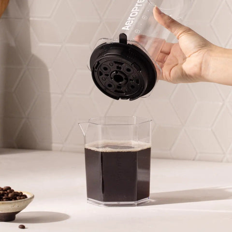 High Performance Flow Control Filter Cap For Manual Coffee Brewers Delivers Complete Brew Command with coffee being poured.