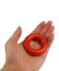 Hand holding one of the Two Pack Golf Swing Weight Rings For Warm Up, 5 Ounces Each, Rubber Coated Metal Rings That Will Not Scratch Your Clubs