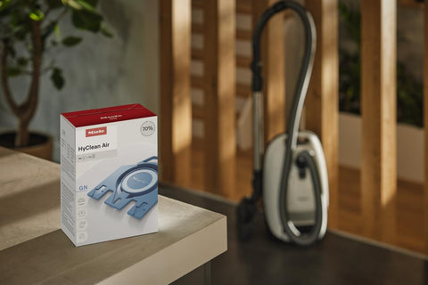 Box of HyClean GN Vacuum Bags Compatible With Complete C2 C3 S8 S5 S2 Canisters on a table next to a vacuum cleaner