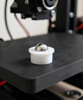 12pcs Steel Ball Transfer Casters with Nylon Housing, 0.7x0.5in on black surface, showcasing a shiny steel ball in white casing.