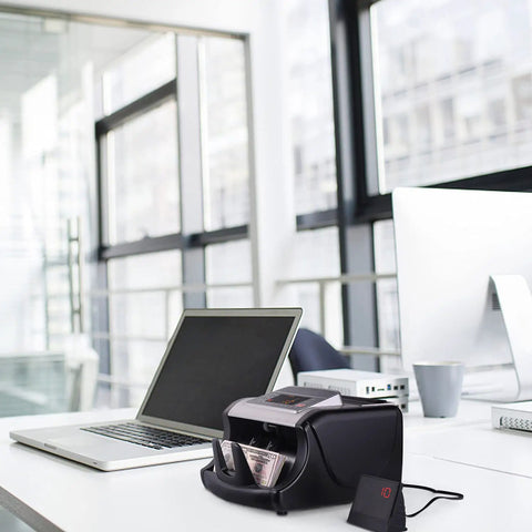 Fast Money Counter Machine With UV MG IR Counterfeit Detection on a modern office desk near a laptop and cup.