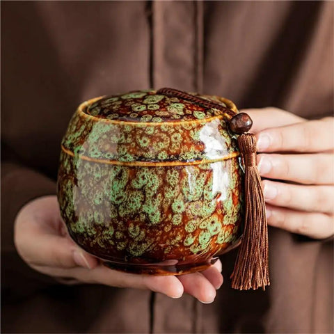 Kick Up Your Pantry Game With These Premium Ceramic Sealed Storage Jars For Loose Tea And Coffee Beans Featuring Ridiculously Tight Lids Really Cool Retro Double Bin Gift Box Organizer, close-up of green and brown ceramic jar with tassel.