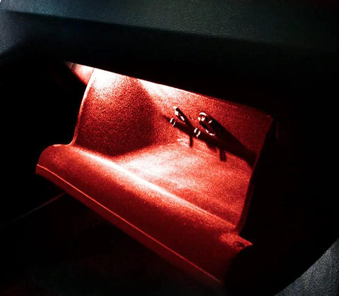 Kickin Red LED Glove Box And Footwell Lights For Volkswagen Vehicles Including Jetta GTI Atlas CC Eos Golf Alltrack Tiguan Touareg 3W 18 SMD Direct Fit Replacement For OEM Incandescent Lamps Super Bright Interior Accent emitting a bright red glow in a vehicle's glove box.