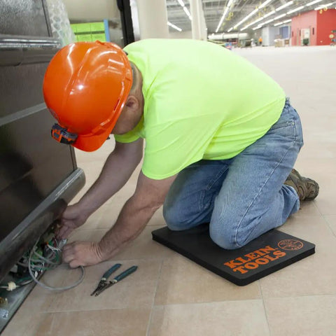 Worker kneeling on 1 Inch Thick NBR Foam Kneeling Pad with Handy Handle for tradesmen, providing ultimate knee protection on job site.