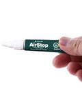 Hand holding a 0.27 oz tube of Airstop Vinyl Repair Sealant For PVC And Inflatable Repairs Waterproof Flexible Patch Up.