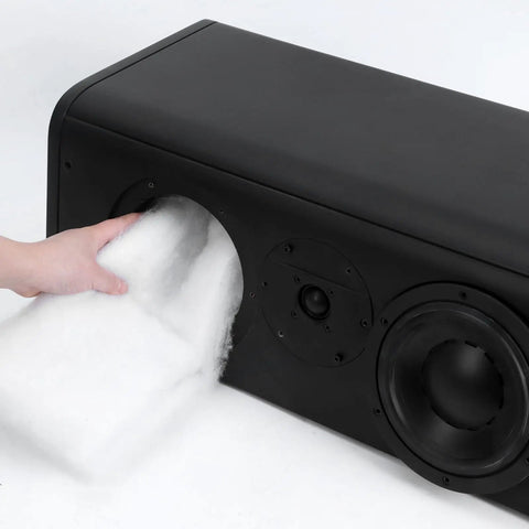 Person inserting Oversized Heavy Weight Polyester Fiber Speaker Damping Fill Sheet into a subwoofer cabinet for acoustic stuffing.