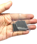 Hand holding a plastic bag with One Eighth Inch Dowel Pins Set, 20 Pieces, One Inch Long Metal Shelf Pins, view of pins in packaging.