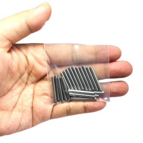 Hand holding a plastic bag with One Eighth Inch Dowel Pins Set, 20 Pieces, One Inch Long Metal Shelf Pins, view of pins in packaging.