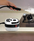 Powerful 2500W Handheld Steam Cleaner With 6 Adjustable Levels And 1L Water Tank in use on kitchen stovetop