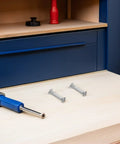 Two Rock Solid 100 Piece Pack M6 Cabinet Panel Binding Bolts made from cold rolled steel on a wooden surface with a tool.