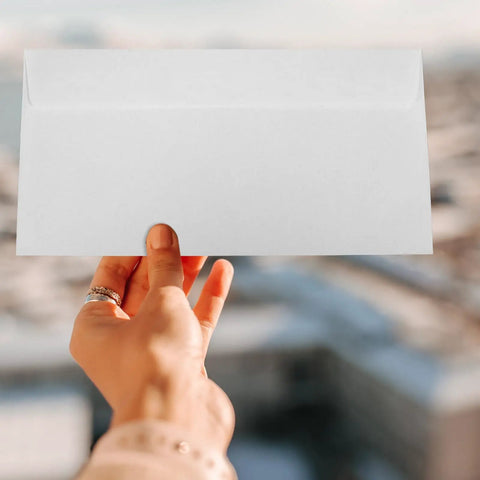 Hand holding a White Self Seal Confidentiality Envelopes 115mm By 225mm For Office Documents And Shipping.