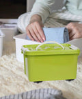 Green box with 6 Pack Stick-On Adhesive Mini Swivel Caster Wheels For Furniture And Appliances on a carpet