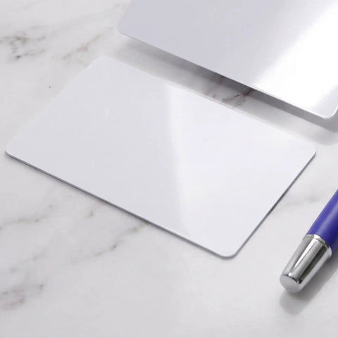 Heavy Duty 50 Piece Set Blank White Pvc Id Cards Dual Sided Printable With Smart Chip Access on marble surface, with pen.