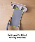 Person positioning a cutting mat onto a Cricut machine. Cutting Mat Variety Pack Four 12 By 24 Inch Mats For Crafting Workhorse Set.
