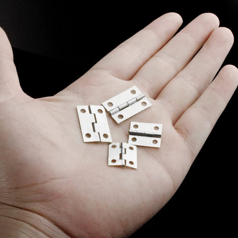 Rock Solid 70 Pcs Mini Hinge Set With 300 Tiny Screws Includes Both 24 X 16 Mm And 18 X 15 Mm Sizes showing durable silver folding butt hinges in hand.