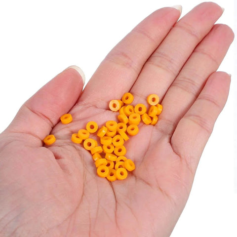 Hand holding 100 Pack Miniature Plastic Bushings and Axle Sleeves for Toy Vehicles, showing orange color and smooth low friction design.