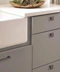 Square Matte Black Cabinet Knobs About An Inch And A Quarter Wide For Kitchen Cabinets, installed on grey drawers.