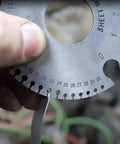 Hand holding a 4140 steel pry bar measuring sheet metal thickness.