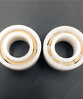 Front view of two white ceramic ball bearings with beige inner rings; R188, 1/4 in x 1/2 in x 3/16 in
