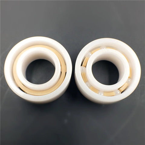 Front view of two white ceramic ball bearings with beige inner rings; R188, 1/4 in x 1/2 in x 3/16 in