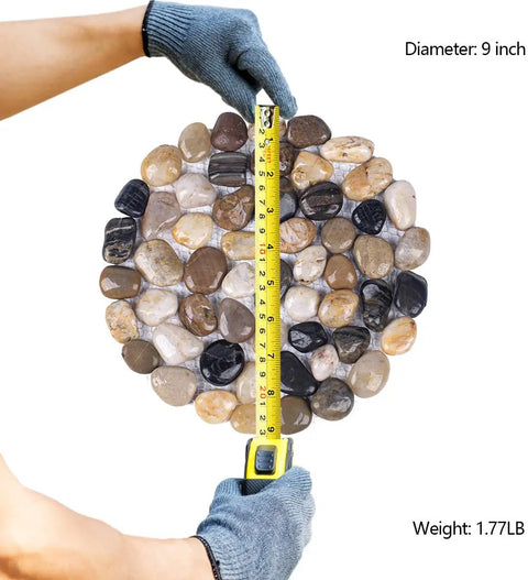 Gloved hands measuring 9-inch polished river rock stepping stones for garden pathway with mesh backing nine inch pebble paver mats six pack.