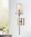 Brushed Nickel Wall Sconce with clear glass shade on white wall