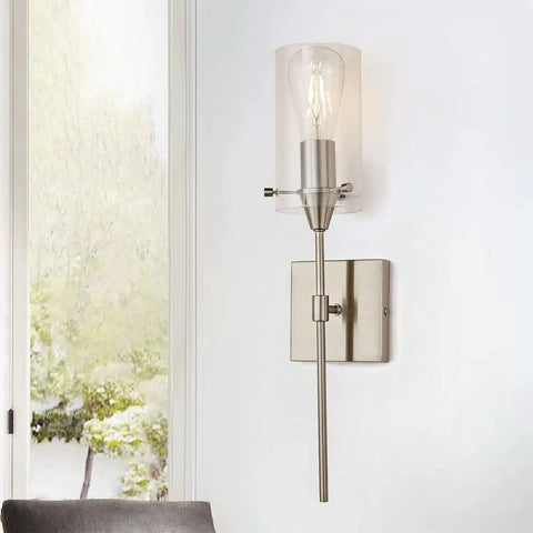 Brushed Nickel Wall Sconce with clear glass shade on white wall