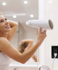 Woman using hair dryer plugged into Black GFCI Outlet 15 Amp Weather Resistant Electrical Receptacle With Decorator Screwless Plate ETL