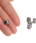 Close-up of a hand holding 10 Piece Set Screw Shaft Collars With 2mm Bore, Stainless Steel 304, 7mm OD, 7mm Width collars next to others on table