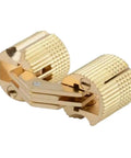 Close-up of brass cylindrical barrel hinge, showcasing concealed mount hardware for cabinets, featuring grooved texture and hinge mechanism.