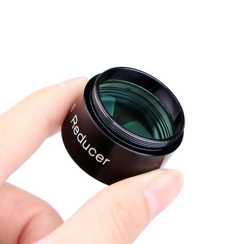0.5x Focal Reducer For 1.25 Inch Eyepieces With Full Multi Coating held between fingers, showing lens and metal body