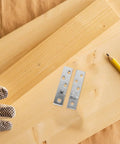 Two Pairs Stainless Steel Pivot Hinges, 360 Degree Rotatable Concealed Door Hinges on wooden planks with pencil