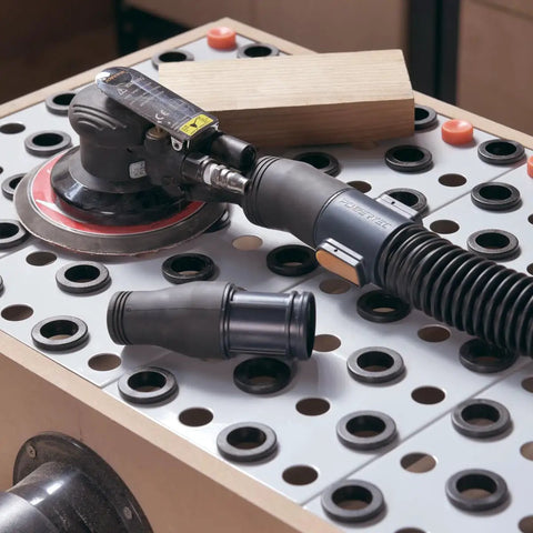Orbital sander connected to 10 Foot Vacuum Hose Kit With 1 Inch And 1 1/2 Inch Quick Change Adapters Plus Two And A Quarter Inch To Two And A Half Inch Dust Port Adapter For Dust Collection Systems Connecting Table Saws And Power Tools To Shop Vacuums on a workbench