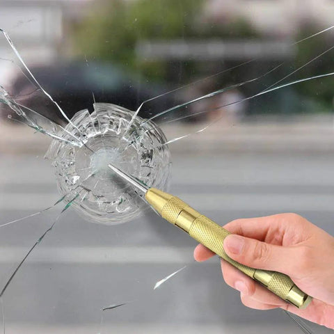 No Sweat Automatic Center Punch Four Piece Kit With Adjustable Spring Impact marking pilot holes on a cracked glass surface.
