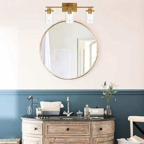 Brushed Brass 3 Light Vanity Light With Clear Glass Shades, Modern Farmhouse Wall Mount Fixture in bathroom setting